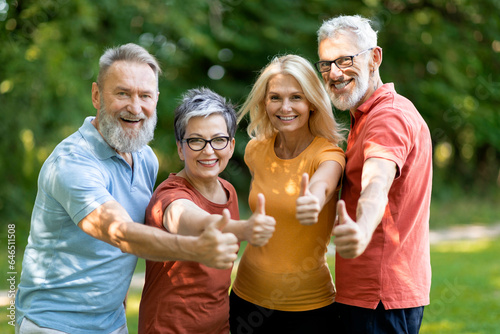 Group Of Sporty Senior People Showing Thumbs Up At Camera Outdoors