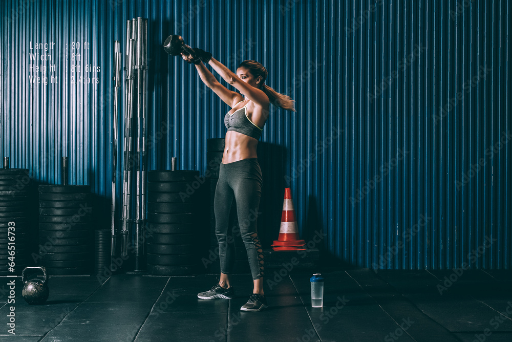 Fit woman training working out lifting kettlebell in Gym Fit woman training working out lifting kettlebell in Gym
