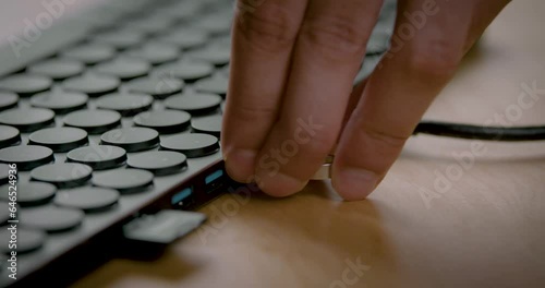 Close-up of male hands inserting a USB flash drive into a keyboard