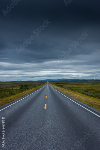 Epic cloudy landscape of an empty highway through the tundra of Norway