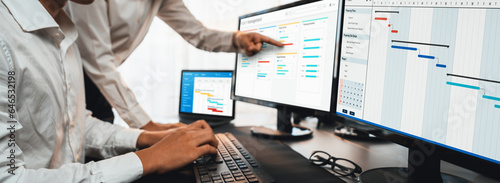 Project management team coordinating and update project planned schedule on computer using Gantt chart software in office. Business people planning time and deadline for company task. Trailblazing