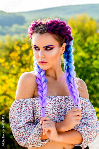 Girl braids. Bright makeup, rose-colored, braids, pigtails hairstyle. Girl with colorful kanekalon braided in her hair. Pretty woman colorful violet ombre hair and pro makeup photo