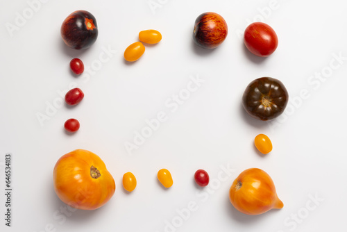 Frame of colorful yellow  red  black tomatoes on white background  top view