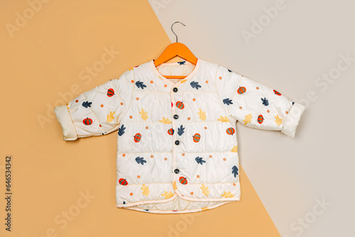 Stylish children's autumn warm jacket on a hanger. Fashion kids outfit for for spring, autumn or winter. Flat lay, top view
