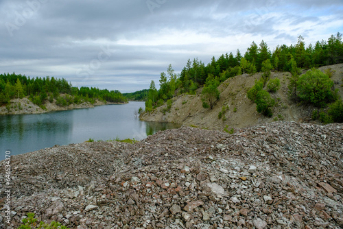 This is a former shale quarry with azure water and picturesque hills. Unlike the Narva shale settling ponds. A dark autumn day. Estonia, Aidu quarry.