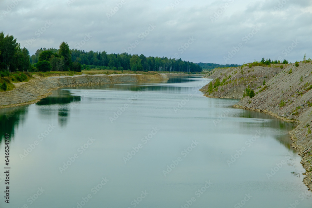 This is a former shale quarry with azure water and picturesque hills. Unlike the Narva shale settling ponds. A dark autumn day. Estonia, Aidu quarry. This is a former shale quarry with azure water and picturesque hills. Unlike the Narva shale settling ponds. A dark autumn day. Estonia, Aidu quarry.
