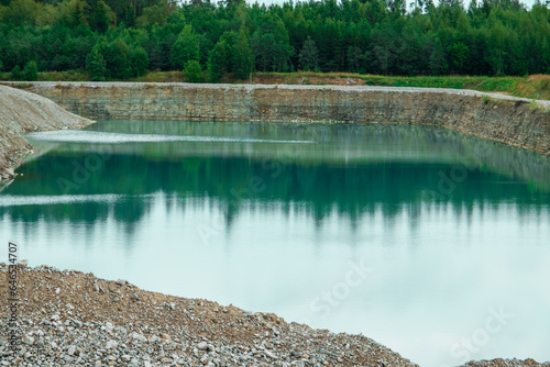 This is a former shale quarry with azure water and picturesque hills. Unlike the Narva shale settling ponds. A dark autumn day. Estonia, Aidu quarry photo