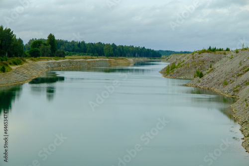 This is a former shale quarry with azure water and picturesque hills. Unlike the Narva shale settling ponds. A dark autumn day. Estonia, Aidu quarry.