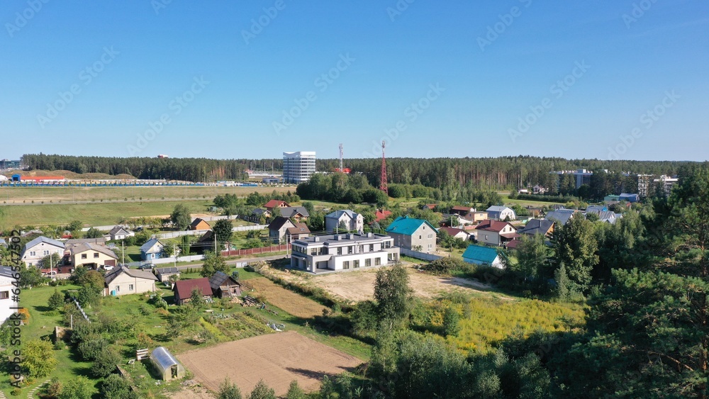 Panoramic views of the modern village. Neighbourhood of private houses (cottages), industrial area and multi-storey residential development. The border of the city and the countryside. Panoramic views of the modern village. Neighbourhood of private houses (cottages), industrial area and multi-storey residential development. The border of the city and the countryside.