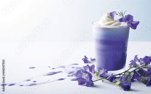 Blue matcha smoothie in a glass on a table decorated with butterfly pea flowers 