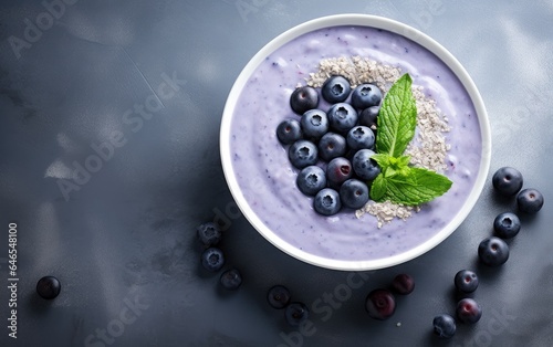 Overhead shot of blue matcha smoothie in a bowl decorated with butterfly pea flowers and berries	
