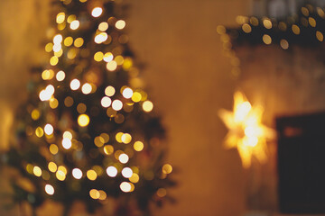 Christmas room golden bokeh. Blurred image of atmospheric christmas eve at fireplace. Defocused illuminated christmas tree and festive fireplace with lights in evening.