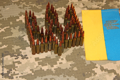 Cartridges for Kalashnikov assault rifle. War Concept. Ukrainian national symbol photo