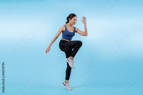 Fototapeta Naklejka Na Ścianę i Meble -  Side view young athletic asian woman on running posture in studio shot on isolated background. Pursuit of healthy fit body physique and cardio workout exercise lifestyle concept. Vigorous