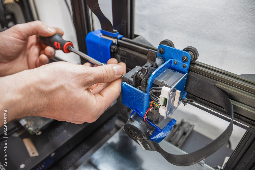 Close-up of technician doing 3D printer repair.