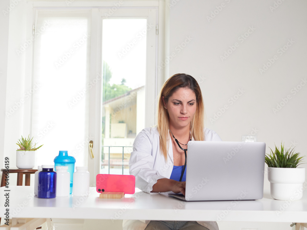 female doctor working on desktop with laptop computer female doctor working on desktop with laptop computer