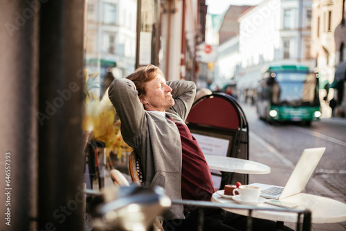 Middle aged businessman taking a break while enjoying a cup of coffee in a cafe in the city