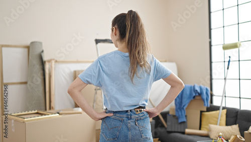 Young beautiful hispanic woman standing on back view at new home © Krakenimages.com