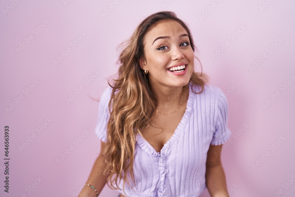 Young hispanic woman standing over pink background smiling cheerful with open arms as friendly welcome, positive and confident greetings Young hispanic woman standing over pink background smiling cheerful with open arms as friendly welcome, positive and confident greetings