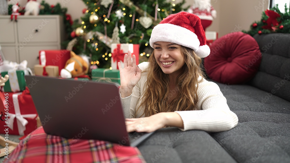 Young beautiful hispanic woman having video call sitting on floor by christmas tree at home Young beautiful hispanic woman having video call sitting on floor by christmas tree at home