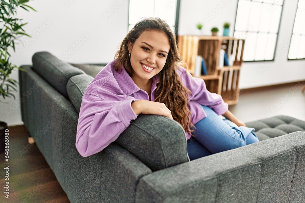 Young beautiful hispanic woman smiling confident sitting on sofa at home Young beautiful hispanic woman smiling confident sitting on sofa at home