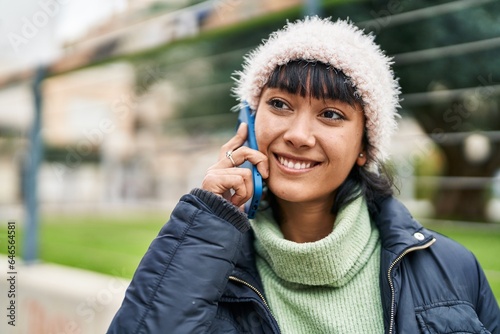 Young beautiful hispanic woman smiling confident talking on smartphone at street