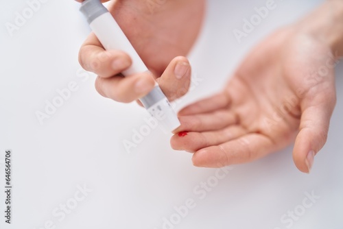 Young woman measuring glucose injecting on finger at home