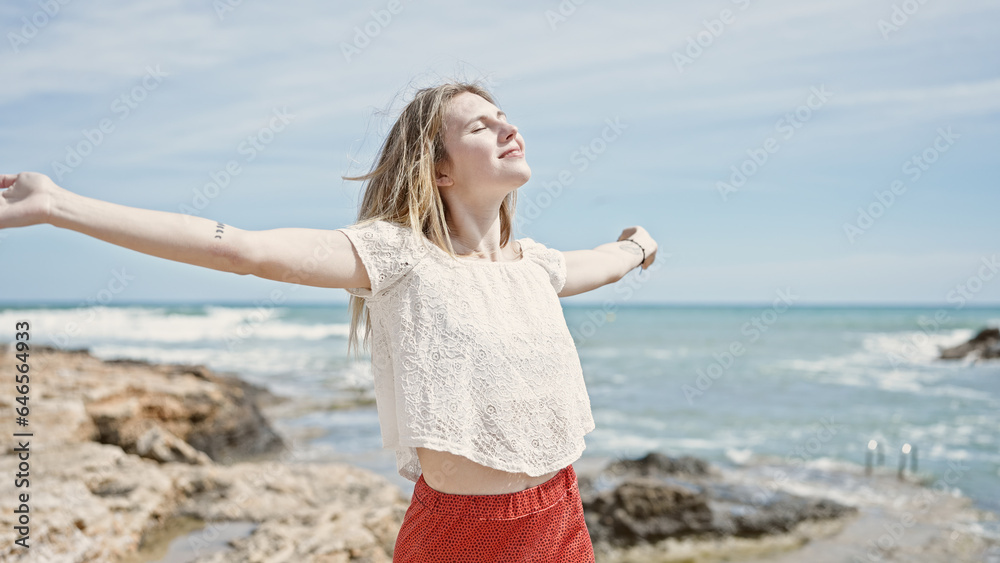 Young blonde woman tourist smiling confident standing with arms open at beach Young blonde woman tourist smiling confident standing with arms open at beach