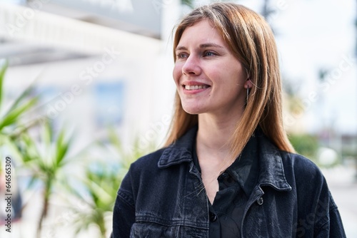 Young blonde woman smiling confident looking to the side at street