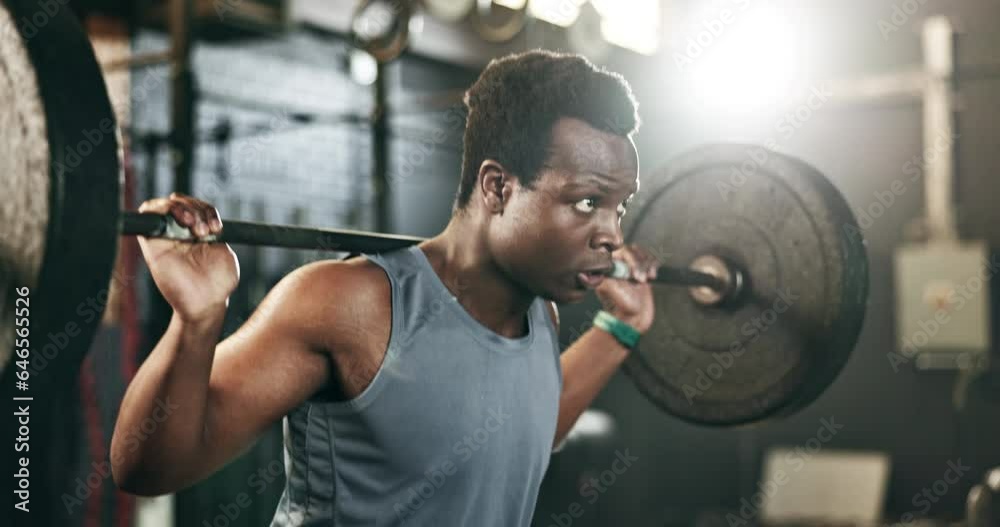 Black man at gym, weight lifting and barbell for muscle building endurance, strong body or balance power in fitness. Commitment, motivation and bodybuilder in workout challenge in health and wellness Black man at gym, weight lifting and barbell for muscle building endurance, strong body or balance power in fitness. Commitment, motivation and bodybuilder in workout challenge in health and wellness