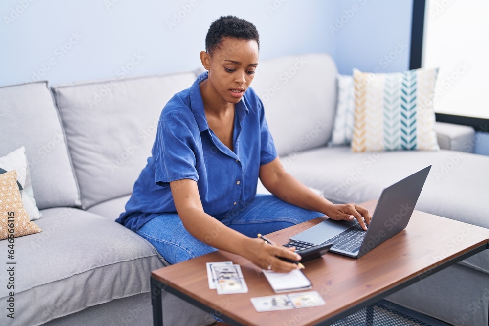 African american woman sitting on sofa accounting at home African american woman sitting on sofa accounting at home