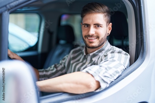 Young caucasian man smiling confident driving car at street