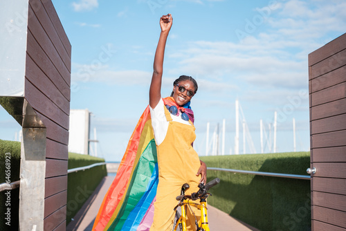 Young woman with the lgtbi flag fighting and showing strength for pride. Concept  lifestyle  pride  outdoors.