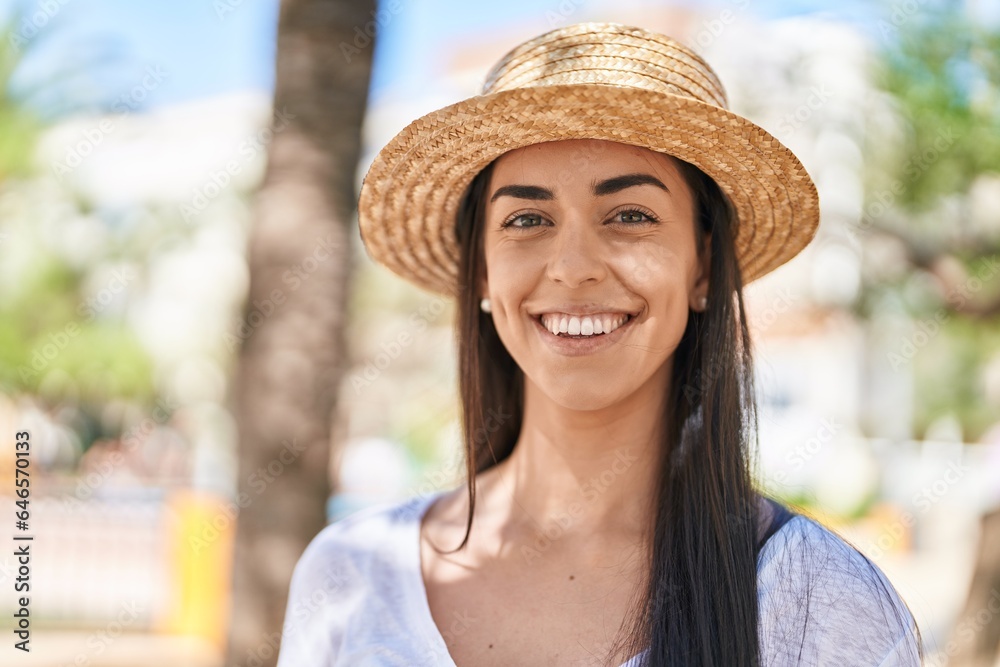 Young hispanic woman tourist smiling confident standing at park