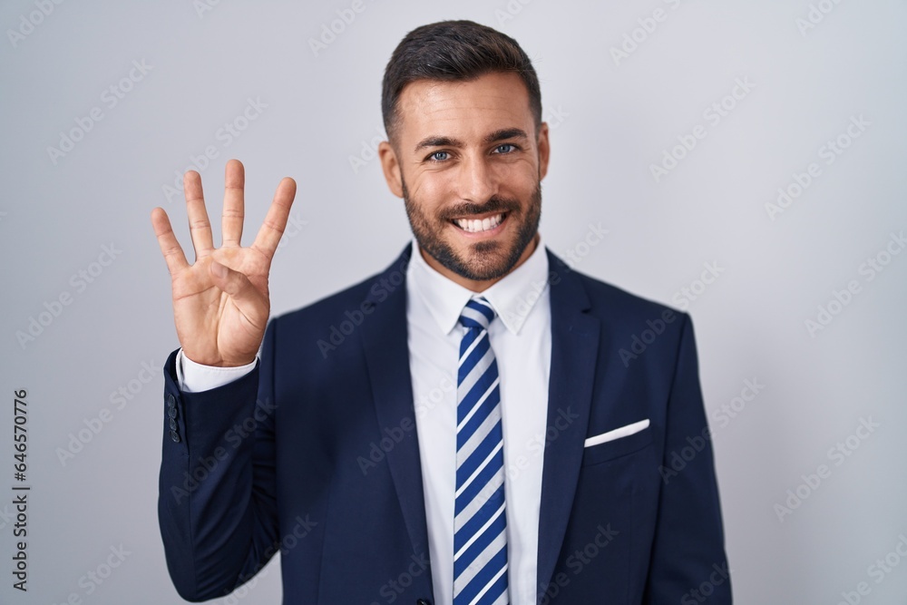 Handsome hispanic man wearing suit and tie showing and pointing up with fingers number four while smiling confident and happy. Handsome hispanic man wearing suit and tie showing and pointing up with fingers number four while smiling confident and happy.
