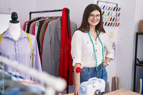 Young caucasian woman tailor smiling confident standing at tailor shop photo