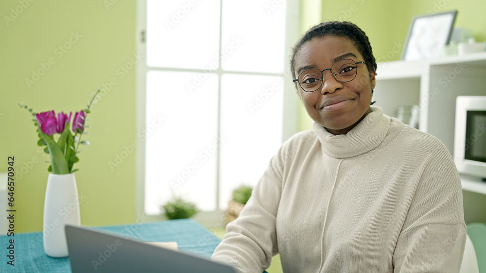 African american woman using laptop sitting on table at dinning room African american woman using laptop sitting on table at dinning room