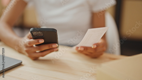 African american woman ecommerce business worker using smartphone doing ticket account at office