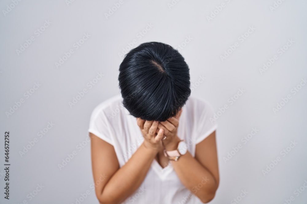 Young asian woman with short hair standing over isolated background with sad expression covering face with hands while crying. depression concept. Young asian woman with short hair standing over isolated background with sad expression covering face with hands while crying. depression concept.