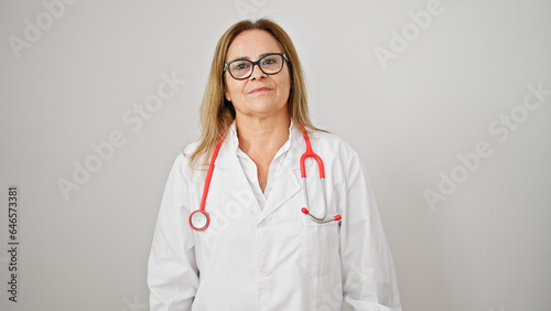 Middle age hispanic woman doctor standing with serious expression over isolated white background