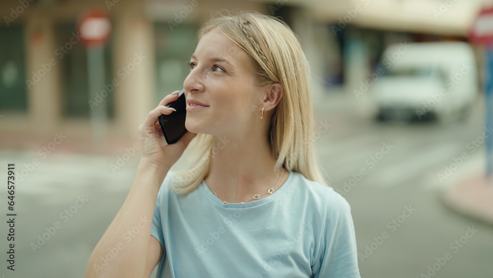 Young blonde woman smiling confident talking on the smartphone at street Young blonde woman smiling confident talking on the smartphone at street