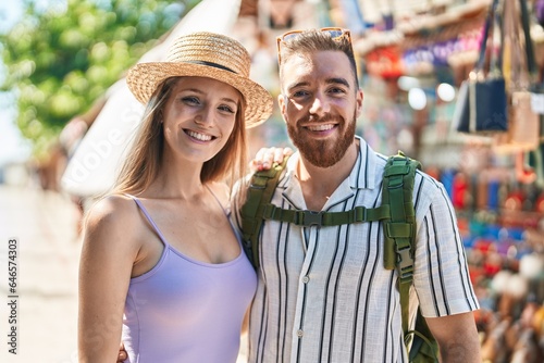 Man and woman tourist couple smiling confident hugging each other at street market © Krakenimages.com