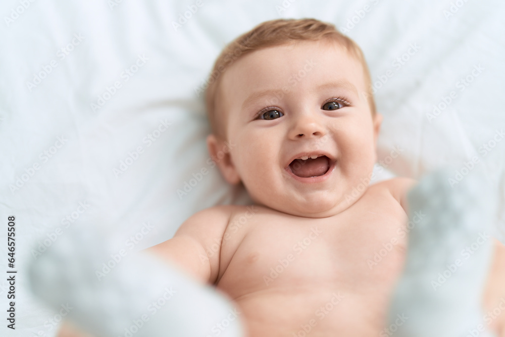 Adorable toddler smiling confident lying on bed at bedroom Adorable toddler smiling confident lying on bed at bedroom