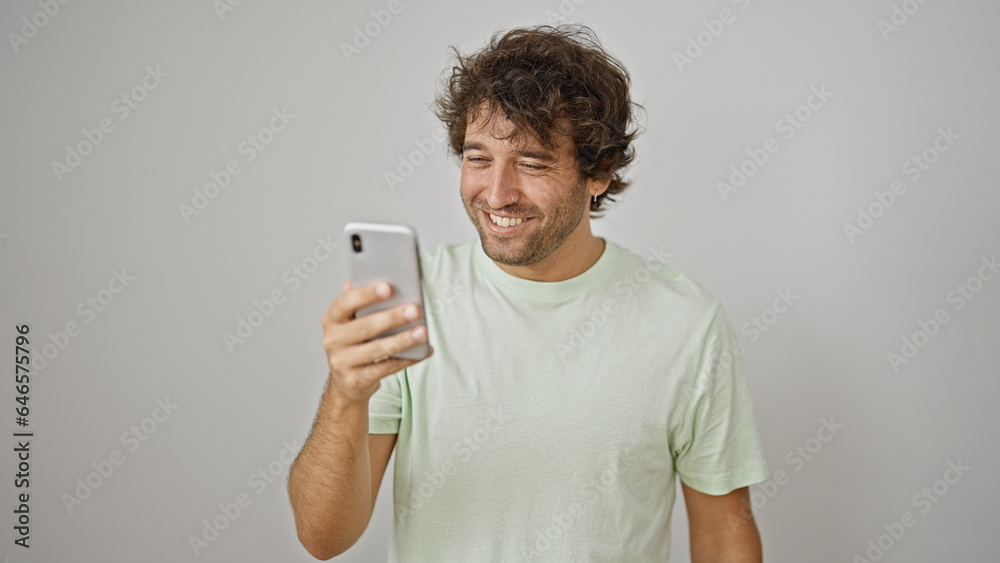 Young hispanic man smiling confident using smartphone over isolated white background Young hispanic man smiling confident using smartphone over isolated white background