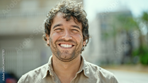 Young hispanic man smiling confident standing at street