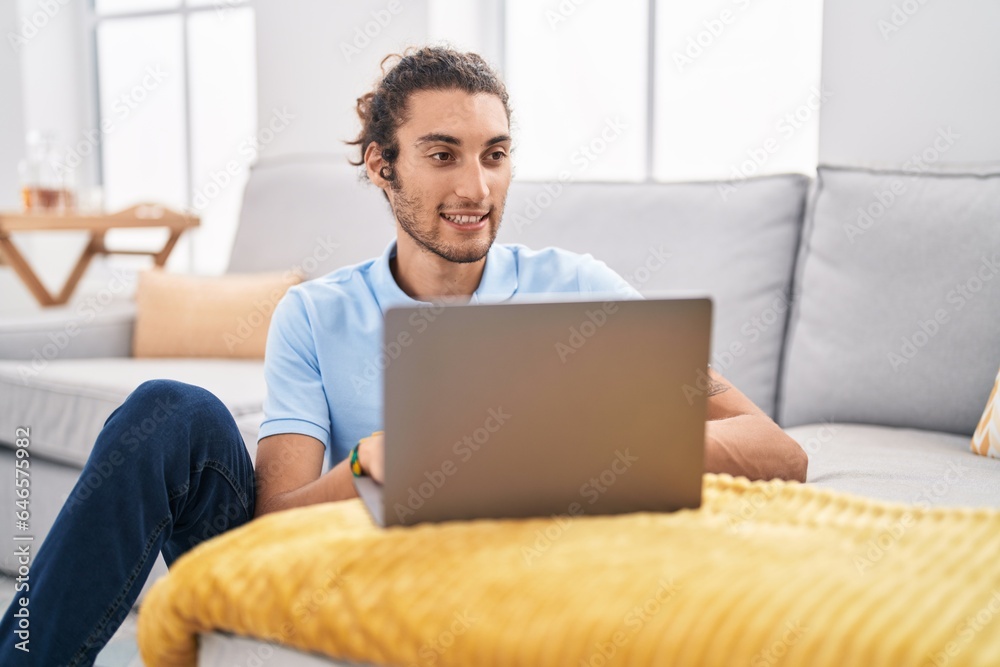 © Krakenimages.com - Young hispanic man using laptop sitting on floor at home