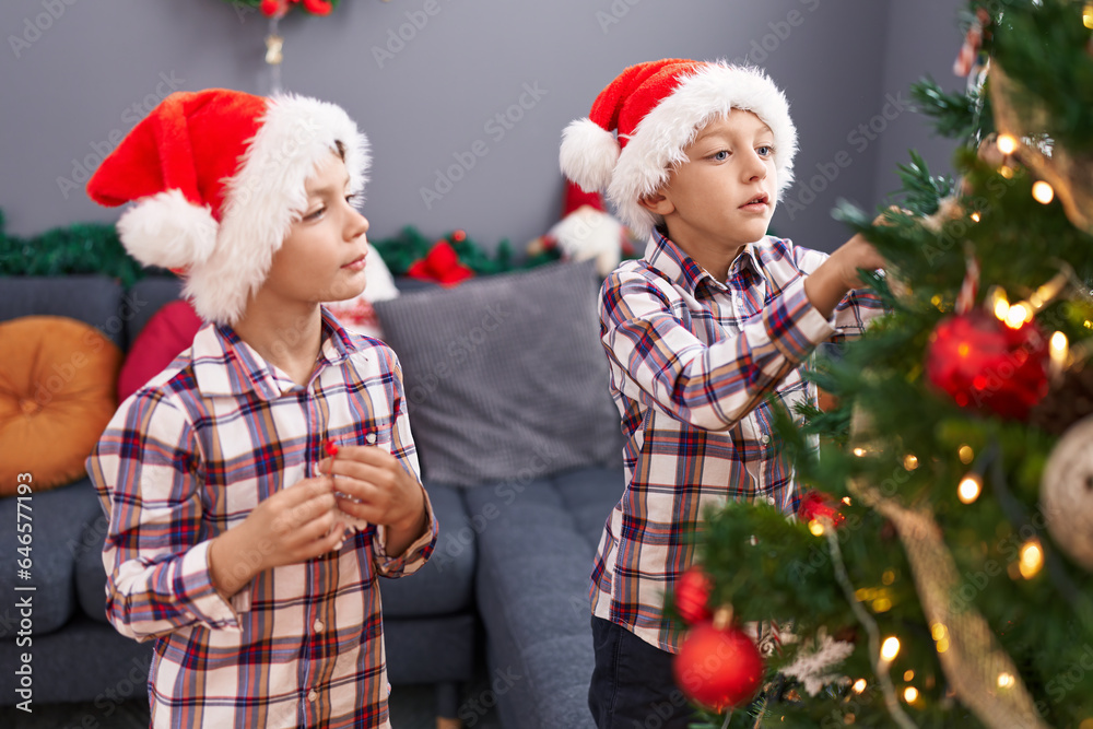 Adorable boys decorating christmas tree at home Adorable boys decorating christmas tree at home