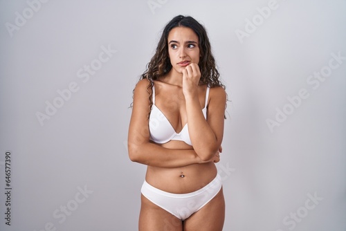 Young hispanic woman wearing white lingerie looking stressed and nervous with hands on mouth biting nails. anxiety problem. © Krakenimages.com