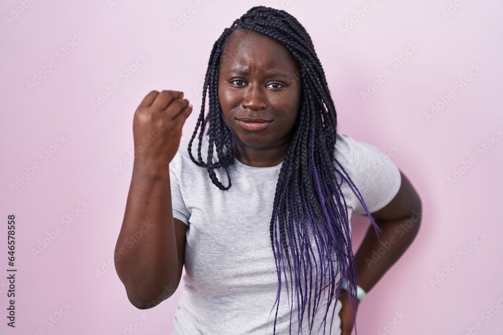 Young african woman standing over pink background doing italian gesture with hand and fingers confident expression