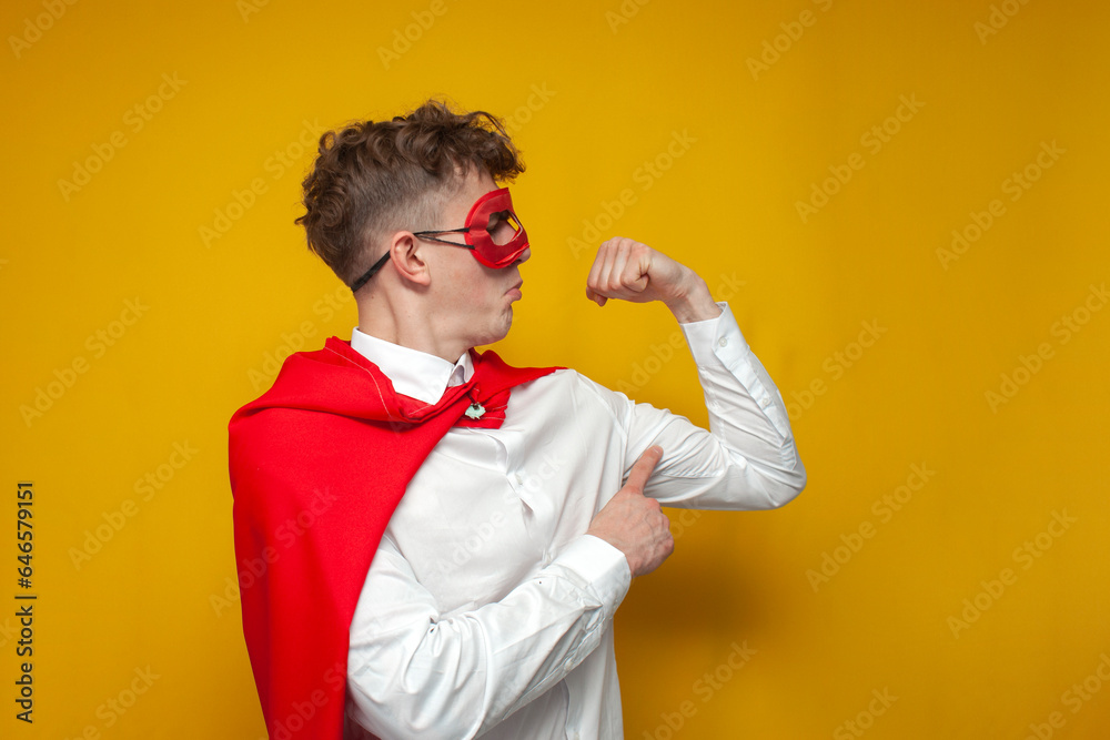 confident guy in a superhero costume shows the muscles on his arm, the concept of a strong man confident guy in a superhero costume shows the muscles on his arm, the concept of a strong man